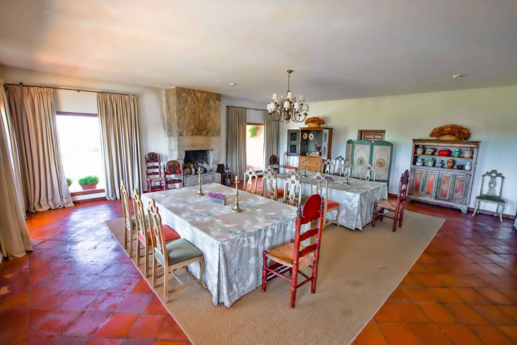 Comedor amplio y luminoso de Finca Valmorisco con mesa grande, sillas elegantes y decoración rústica